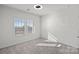 A bright bedroom featuring neutral carpet, two large windows, and a ceiling fan at 3012 Seville St, Charlotte, NC 28214