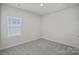 Clean bedroom with neutral carpet, one large window, and a ceiling fan at 3012 Seville St, Charlotte, NC 28214