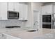 Modern kitchen with stainless steel appliances, white cabinetry, and a stylish tile backsplash at 3012 Seville St, Charlotte, NC 28214