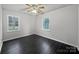 A spacious bedroom with two windows and dark hardwood floors at 316 Epperstone Ln, Matthews, NC 28105