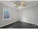 A bedroom featuring wood floors, a ceiling fan, and a bright window at 316 Epperstone Ln, Matthews, NC 28105