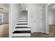 A staircase with black stairs and white risers leads to the upper level of the home at 316 Epperstone Ln, Matthews, NC 28105