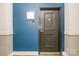 A stylish front door is set against a blue accent wall, creating a modern and welcoming entrance at 3920 Sharon Rd # 208, Charlotte, NC 28211