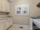 Well-lit laundry room with shaker cabinets, granite counters, and a window with white shutters at 462 Barber Loop, Mooresville, NC 28117