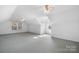 Large finished attic with white walls, ceiling fans, and dormer windows for natural light at 468 White Oak Branch Rd, Statesville, NC 28625