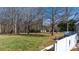 Large, grassy backyard with mature trees, landscaping, and fenced perimeter at 468 White Oak Branch Rd, Statesville, NC 28625