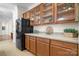 Traditional-style kitchen featuring wooden cabinets, glass-front displays, and a modern black refrigerator at 468 White Oak Branch Rd, Statesville, NC 28625