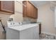 Laundry room features a washer, dryer, and wooden cabinets for storage at 468 White Oak Branch Rd, Statesville, NC 28625