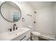 Modern bathroom with a circular mirror, white vanity, and walk-in shower, blending style and functionality at 523 Hickory Nut Ln, China Grove, NC 28023
