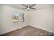 This bedroom features neutral paint, a ceiling fan, wood floors, and large windows for ample natural light at 523 Hickory Nut Ln, China Grove, NC 28023