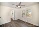 Bright bedroom with light walls, wood floors, ceiling fan, and view of the neighborhood through large windows at 523 Hickory Nut Ln, China Grove, NC 28023