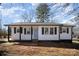 Charming home showcasing light blue front door, black shutters, and white siding under a partly cloudy sky at 523 Hickory Nut Ln, China Grove, NC 28023