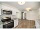 Kitchen featuring stainless steel appliances, white cabinets, granite countertops, and wood flooring at 523 Hickory Nut Ln, China Grove, NC 28023