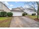 A spacious two car garage and driveway, perfect for additional parking, surrounded by greenery at 6623 Latherton Ln, Charlotte, NC 28278