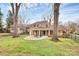 Expansive backyard view featuring a brick home and covered patio with a large manicured lawn at 7141 Lancer Dr, Charlotte, NC 28226