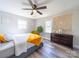 Bright bedroom with decorative wall art, two windows, wood-look floors and a comfy queen sized bed at 8208 Doverdale Ln, Charlotte, NC 28217