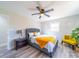 Cozy bedroom featuring a decorative ceiling fan, neutral walls, wood-look floors and a comfy queen sized bed at 8208 Doverdale Ln, Charlotte, NC 28217