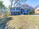 Charming two-story home features a blue painted brick and siding exterior with black shutters and a vibrant blue front door at 8208 Doverdale Ln, Charlotte, NC 28217