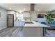 Bright kitchen with white cabinets, stainless steel appliances, laminate floors and a spacious island with a quartz countertop at 8208 Doverdale Ln, Charlotte, NC 28217