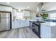 Modern kitchen boasts white cabinetry, stainless steel appliances, quartz countertops, and a sleek range hood at 8208 Doverdale Ln, Charlotte, NC 28217
