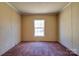 Empty bedroom with neutral walls, window with natural light, and carpeted floor at 828 Carver St, Shelby, NC 28152
