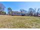 Charming single-story home with classic horizontal siding, complemented by a well-manicured lawn and mature trees at 828 Carver St, Shelby, NC 28152