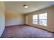 Bright living room with large windows and plush carpeting, perfect for relaxation and entertaining at 828 Carver St, Shelby, NC 28152