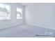 Bright bedroom featuring two windows and neutral carpet at 000 Millstream Rd # 149, Denver, NC 28037