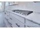 Close-up of the sleek stainless steel gas cooktop and bright countertop in this modern kitchen at 000 Millstream Rd # 149, Denver, NC 28037