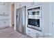 Modern white kitchen featuring stainless steel appliances and light wood flooring at 000 Millstream Rd # 149, Denver, NC 28037