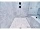 Walk-in shower with gray tile, mosaic floor, and black fixtures at 000 Millstream Rd # 149, Denver, NC 28037