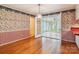 Cozy dining area with hardwood floors, decorative wallpaper, and entry to a bright sunroom at 1007 Wentworth Dr, Kannapolis, NC 28081