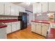 Spacious kitchen with red countertops, white cabinetry, and classic wallpaper at 1007 Wentworth Dr, Kannapolis, NC 28081