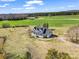 Aerial view of a home with a pond, surrounded by green fields and mature trees, under a bright blue sky with clouds at 107 Sunderland Dr, Shelby, NC 28150