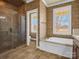 Bathroom featuring a glass shower, soaking tub, and large windows for natural light at 107 Sunderland Dr, Shelby, NC 28150