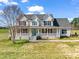 Charming two-story home with a welcoming front porch and blue door, set on a lush green lawn under a bright blue sky at 107 Sunderland Dr, Shelby, NC 28150