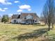 Back view of two-story home, showcasing a screened porch and serene pond views, with a spacious backyard and mature trees at 107 Sunderland Dr, Shelby, NC 28150