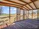 Inviting screened porch showcasing exposed beams, wood flooring, and an expansive view of the adjacent field at 107 Sunderland Dr, Shelby, NC 28150