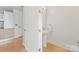 Small bathroom featuring a pedestal sink, hardwood floors and a door leading to other parts of the unit at 1133 Metropolitan Ave # 310, Charlotte, NC 28204