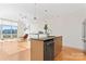 Open kitchen features an island bar with sink, dishwasher, granite countertops, and hardwood flooring at 1133 Metropolitan Ave # 310, Charlotte, NC 28204