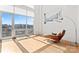 Open living room has a large sunny window with a balcony and a modern floor lamp plus chair and ottoman at 1133 Metropolitan Ave # 310, Charlotte, NC 28204