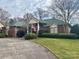 Beautiful brick home with lush landscaping and American flag waving in the front yard at 1217 12Th Fairway Nw Dr, Concord, NC 28027