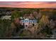Aerial view of estate at sunset, surrounded by mature trees and lush greenery at 131 The Point Dr, Mooresville, NC 28117