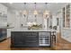 Gourmet kitchen boasts a large center island, wine fridge, marble countertops, and elegant chandelier lighting at 131 The Point Dr, Mooresville, NC 28117
