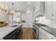 Modern kitchen featuring stainless steel appliances, a center island with sink, and custom range hood at 131 The Point Dr, Mooresville, NC 28117
