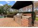 Covered brick outdoor kitchen with built-in stainless steel grill and counter space at 131 The Point Dr, Mooresville, NC 28117