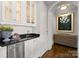 Elegant wet bar with granite countertops, a sink, and glass-front cabinets at 131 The Point Dr, Mooresville, NC 28117