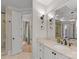 Bright bathroom features a large mirror, white vanity with a marble countertop, and matte black accents at 13215 Claysparrow Rd, Charlotte, NC 28278