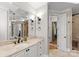 Bright bathroom features a large mirror, white vanity with a marble countertop, and matte black accents at 13215 Claysparrow Rd, Charlotte, NC 28278