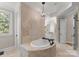 Luxurious bathroom with a jetted tub, chandelier, and vanity with storage at 13215 Claysparrow Rd, Charlotte, NC 28278